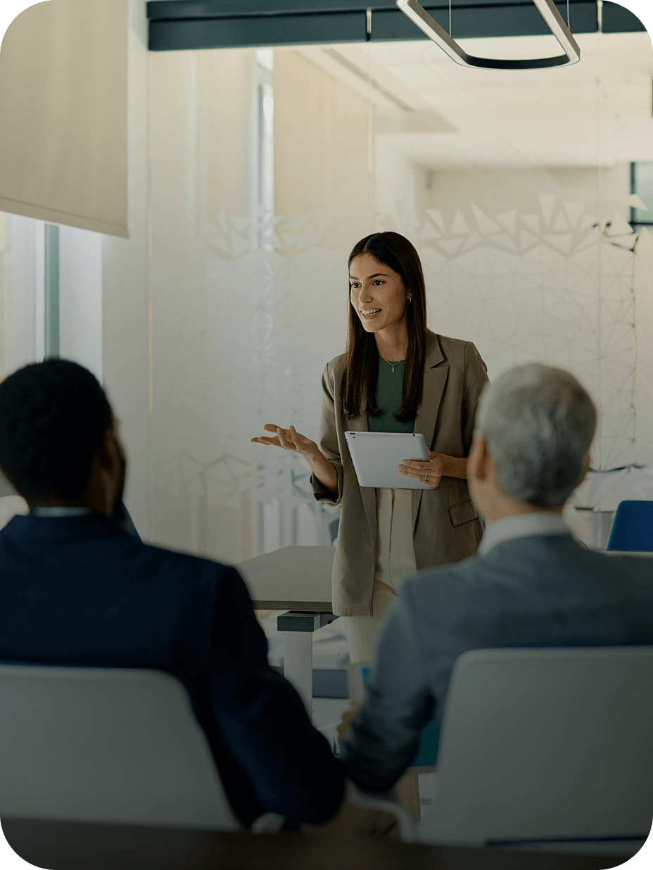 Woman presenting to colleagues in office meeting.