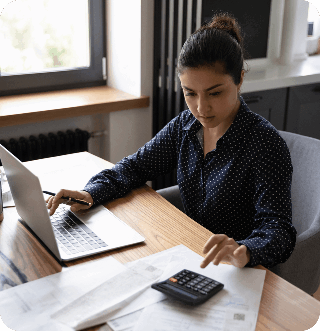 Woman working on laptop and calculator.