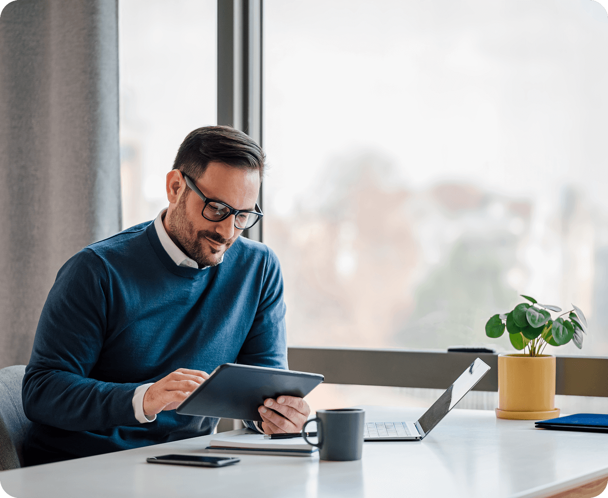 Man working on tablet at desk.