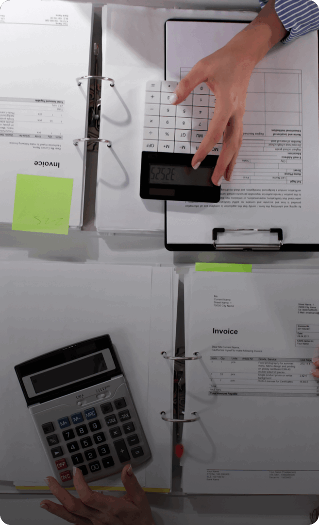 Calculators and invoices on a desk.