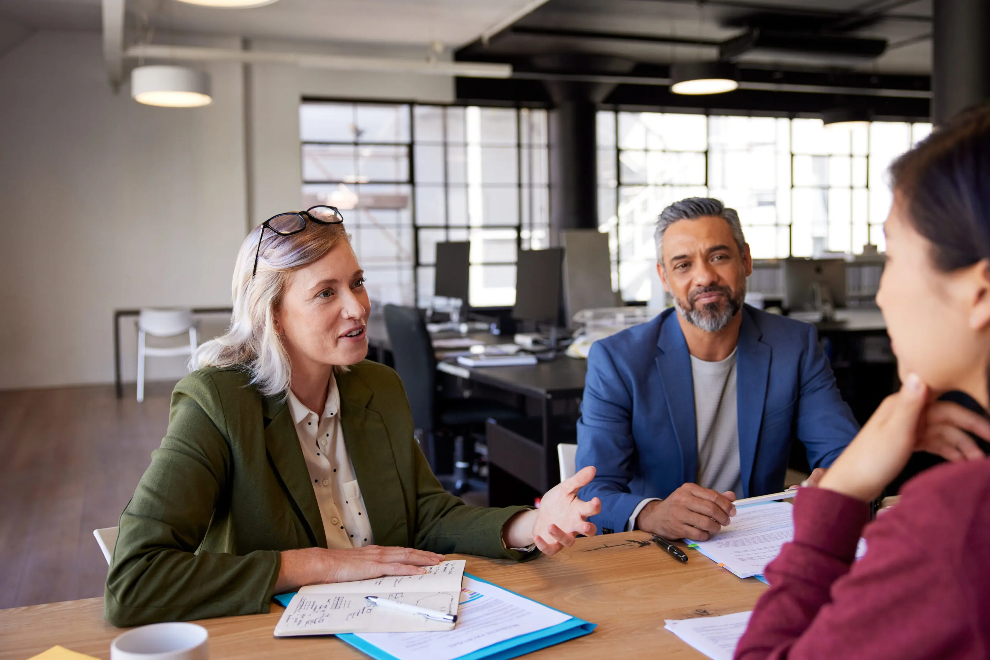 Business colleagues discussing strategies and ideas in office. Smiling woman interviewing candidate for job selection in company. Happy recruiter taking and interview a candidate with the help of a human resources manager.